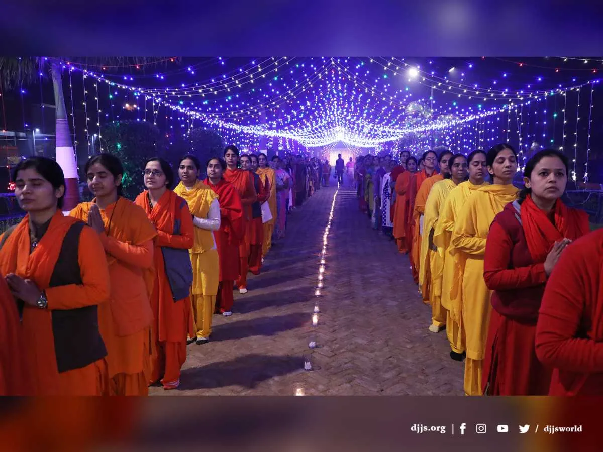 Disciples lining a path beneath a canopy of lights at Divya Dham Ashram on Diwali 2021