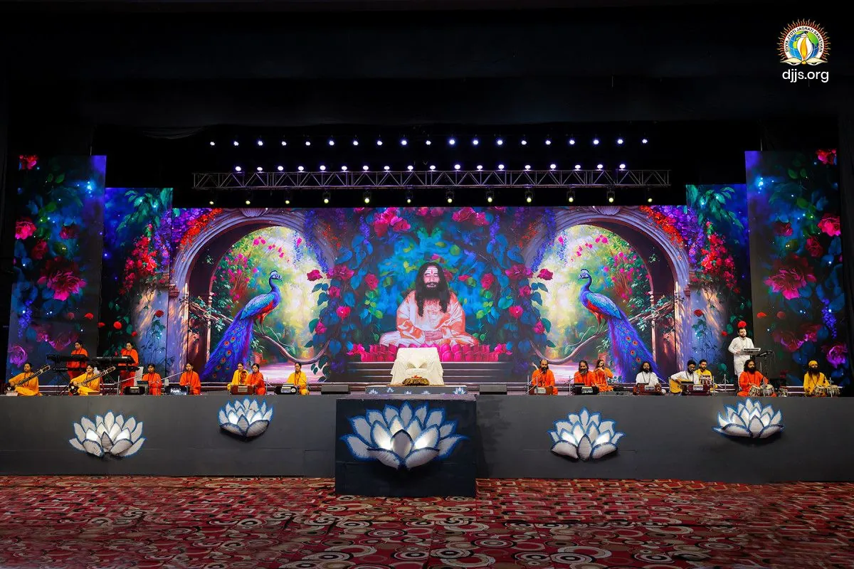 The stage of Shri Guru Purnima Mahotsav 2025 at Divya Dham Ashram, with floral peacocks and lotus lamps